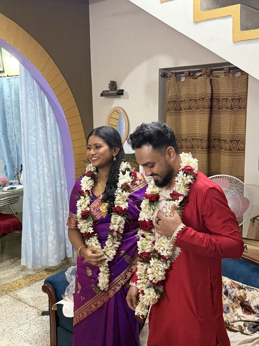 Man in white kurta placing arm on Rituparna's head in blessing