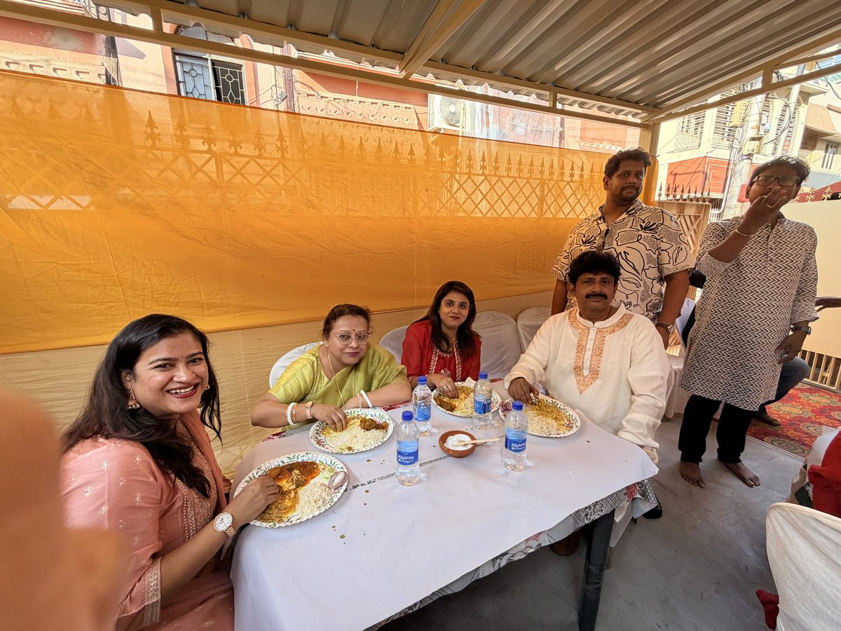 Family members sitting at a white table eating under the orange tent