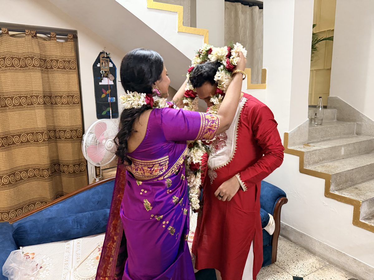 Shoumo placing a flower garland on Rituparna's head as she smiles